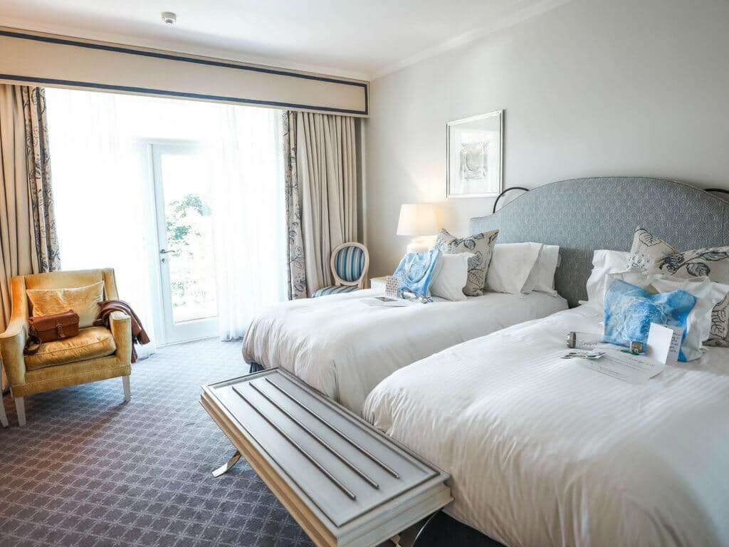 A bright hotel room. Use these secret travel hacks for better flights, hotels, and cruises! Along with tips on how to avoid lines, pick the best travel destinations, and more! And for more travel tips and wanderlust inspiration, follow The Scenic Suitcase on Pinterest!