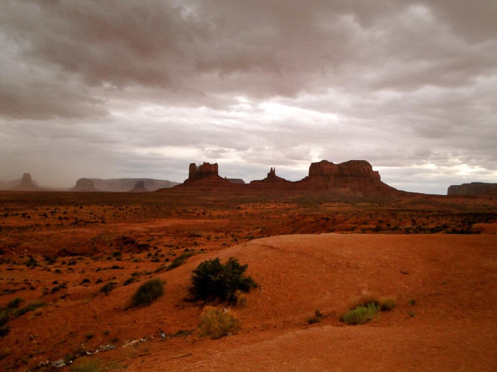 A sandstorm approaching Monument Valley. Discover some of the most beautiful places in the American Southwest. Awe-inspiring destinations and what you shouldn't miss on your next road trip! And for more travel tips and wanderlust inspiration, follow The Scenic Suitcase on Pinterest!