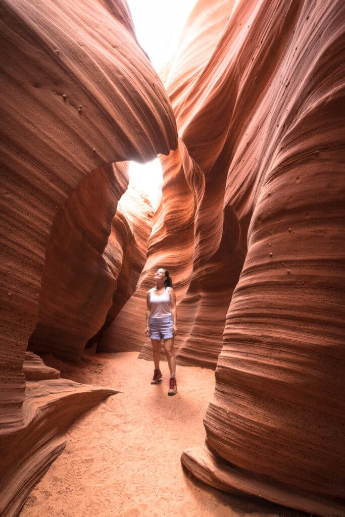 A girl standing in Antelope Canyon. Discover some of the most beautiful places in the American Southwest. Awe-inspiring destinations and what you shouldn't miss on your next road trip! And for more travel tips and wanderlust inspiration, follow The Scenic Suitcase on Pinterest!
