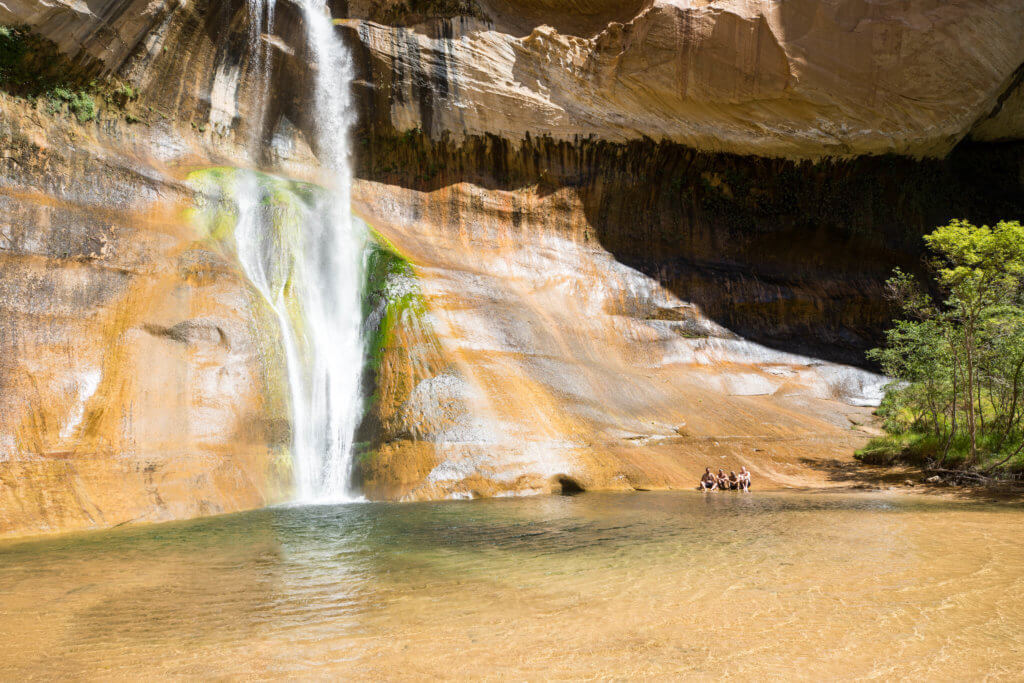 Four guys sitting near a waterfall and trees. Discover some of the most beautiful places in the American Southwest. Awe-inspiring destinations and what you shouldn't miss on your next road trip! And for more travel tips and wanderlust inspiration, follow The Scenic Suitcase on Pinterest!
