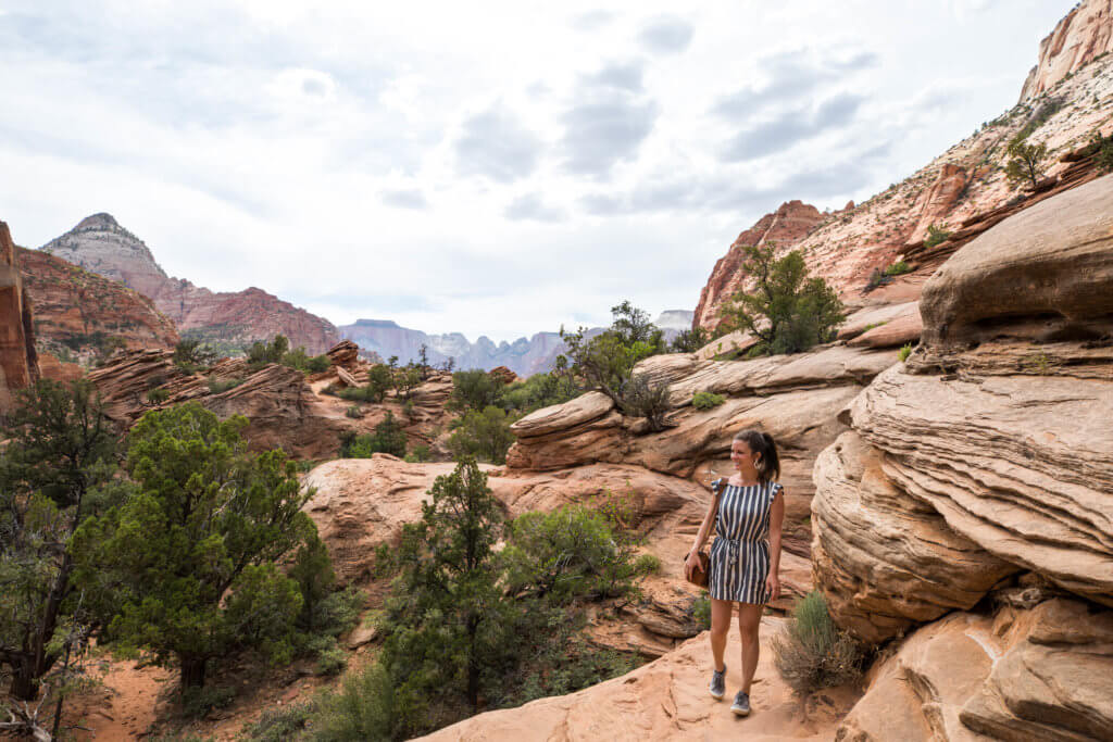 A girl walking near a rock trail in Zion National Park. Discover some of the most beautiful places in the American Southwest. Awe-inspiring destinations and what you shouldn't miss on your next road trip! And for more travel tips and wanderlust inspiration, follow The Scenic Suitcase on Pinterest!