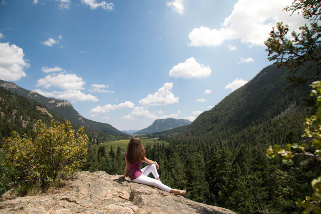 Girl sitting alone at the top of a mountain. Discover 10 reasons to travel solo, and why seeing the world on your own will rock your socks off. Surprising perks, life-changing opportunities, and more! And for additional travel tips and wanderlust inspiration, follow The Scenic Suitcase on Pinterest!
