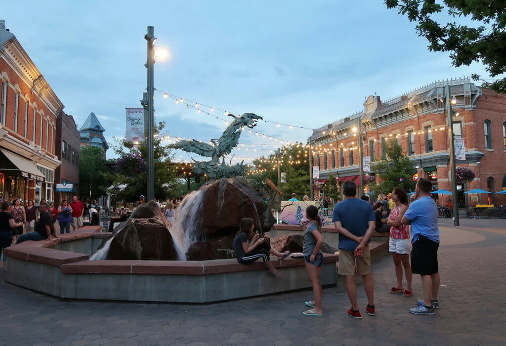 The fountain in Old Town Square in Fort Collins lit up by hanging string lights. Discover the most stunning, offbeat, and unique places in Colorado. Including cliff diving dinner entertainment, haunted hotels, towering dunes, and more! And for additional travel tips and wanderlust inspiration, follow The Scenic Suitcase on Pinterest!