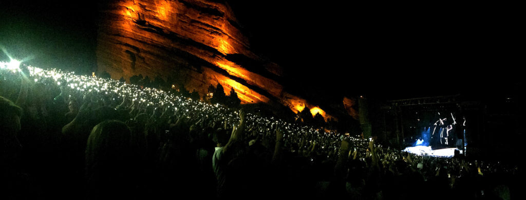 Cell phone lights at a night concert at Red Rocks. Discover the most stunning, offbeat, and unique places in Colorado. Including cliff diving dinner entertainment, haunted hotels, towering dunes, and more! And for additional travel tips and wanderlust inspiration, follow The Scenic Suitcase on Pinterest!