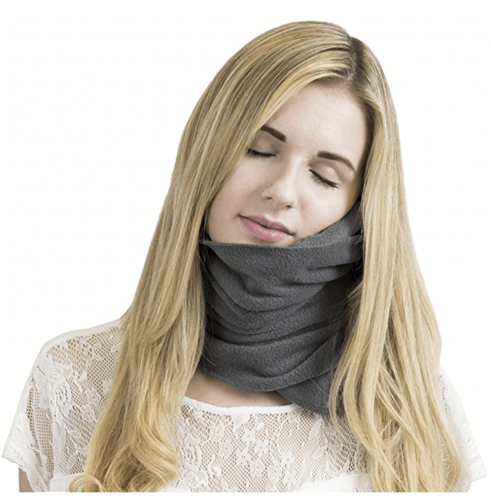 A grey Trtl travel pillow with a sleeping blonde woman. Discover the top 10 travel essentials every globetrotter needs. These helpful (and sometimes surprising) accessories will transform the way you travel! And for more travel tips and wanderlust inspiration, follow The Scenic Suitcase on Pinterest!