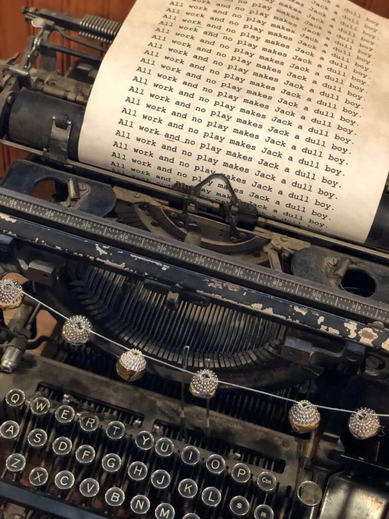 An old typewriter with "All work and no play makes Jack a dull boy" typed over and over on a sheet of paper. The Stanley Hotel has classic charm, an intriguing past, and otherwordly guests. Discover what it's like to meet ghosts on a Stanley Hotel haunted tour! And for more travel tips and wanderlust inspiration, follow The Scenic Suitcase on Pinterest!