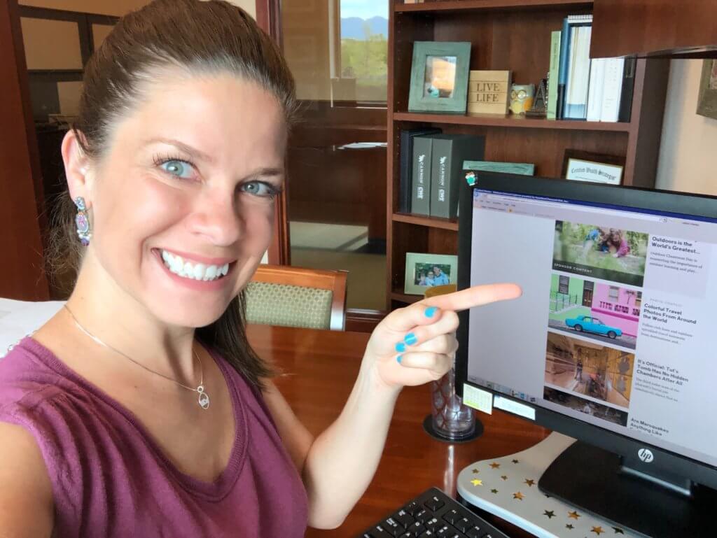 Girl pointing at a computer screen and smiling. After 100 posts, discover unexpected life lessons learned from blogging. Transformative changes, shocking realizations, and what it really takes to succeed. And for travel tip and wanderlust inspiration, follow The Scenic Suitcase on Pinterest!