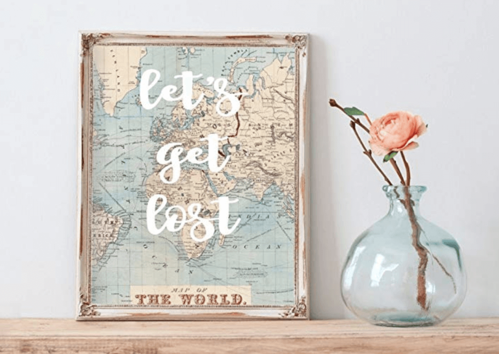 A "Let's Get Lost" map print sitting next to a vase with a pink rose. Stylish, afforable, and fun travel inspired home decor that's perfect for anyone with a serious case of wanderlust. Find that perfect accent for your home! And for more travel tips and wanderlust inspiration, follow The Scenic Suitcase on Pinterest!