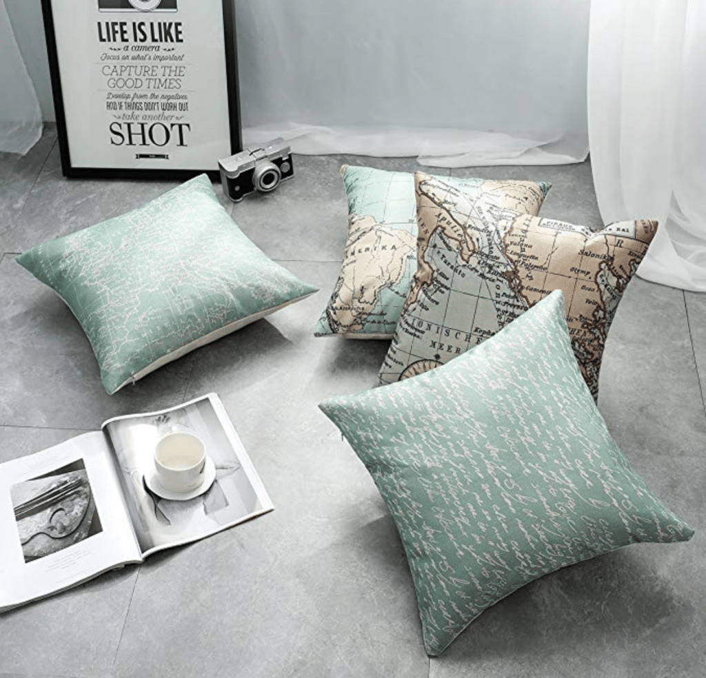 Mint colored map pillows sitting on the floor near a book and a camera. Stylish, afforable, and fun travel inspired home decor that's perfect for anyone with a serious case of wanderlust. Find that perfect accent for your home! And for more travel tips and wanderlust inspiration, follow The Scenic Suitcase on Pinterest!