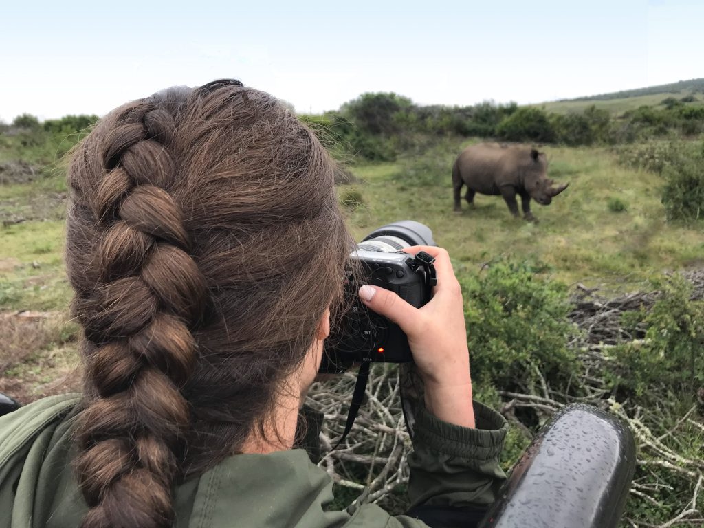 A girl photographing a rino. See the most picture perfect moments of 2018. From London to Cape Town to Las Vegas and more, see what you can't miss in these incredible destinations! And for more travel tips and wanderlust inspiration, follow The Scenic Suitcase on Pinterest!