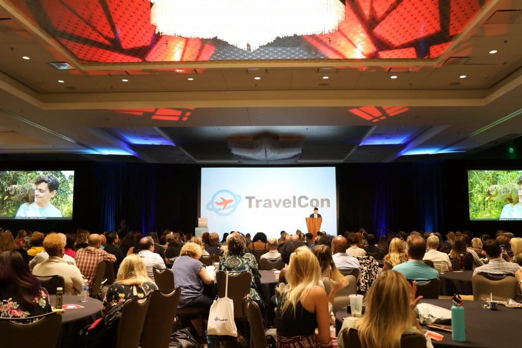 A man speaking in a large conference room. See the most picture perfect moments of 2018. From London to Cape Town to Las Vegas and more, see what you can't miss in these incredible destinations! And for more travel tips and wanderlust inspiration, follow The Scenic Suitcase on Pinterest!