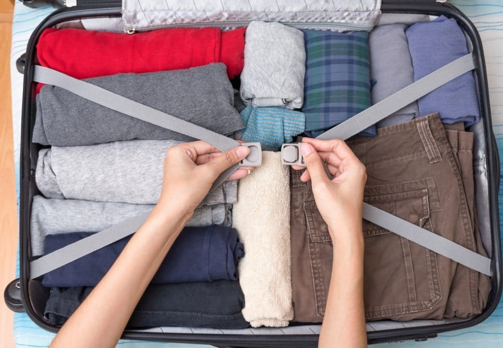 Woman packing an organized suitcase. Holiday travel can become an absolutely nightmare for the unprepared. Instead, use these expert travel tips for holiday travel and save your sanity! And for more travel tips and wanderlust inspiration, follow The Scenic Suitcase on Pinterest!