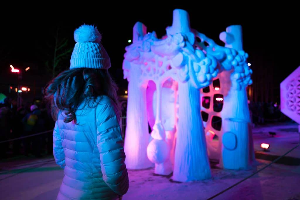 A girl looking at a large snow sculpture. One of the most picture perfect moments of 2019. #2019 #SnowSculptureFestival