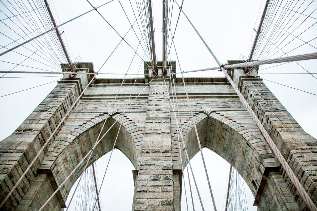 A shot looking up at the Brooklyn Bridge. Discover 10 photography ideas to boost your creativity! Get out of the slump and get shooting! And for more tips, follow The Scenic Suitcase on Pinterest! #photographytips #photographyinspiration