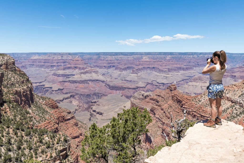 Girl taking a photo of the Grand Canyon.