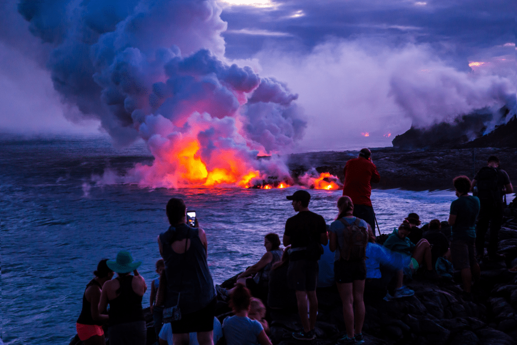 People watching lava in Volcanoes National Park. Discover the 10 best U.S. National Parks you should definitely add to your bucket list.
