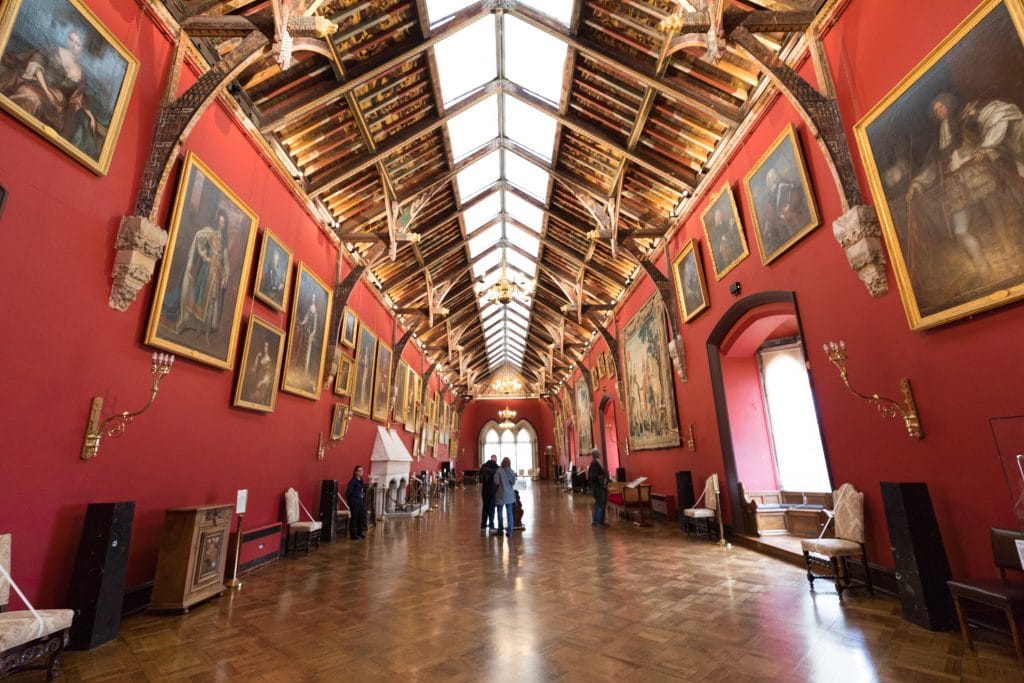 A massive red room in the Kilkenny Castle with art along the walls. There are countless reasons to visit Ireland. Discover 8 of the most amazing places you really shouldn't miss on your next trip to the emerald isle!