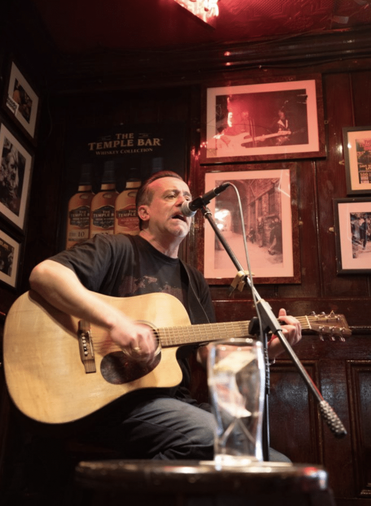 A singer with a guitar performing at The Temple Bar. #TempleBar
