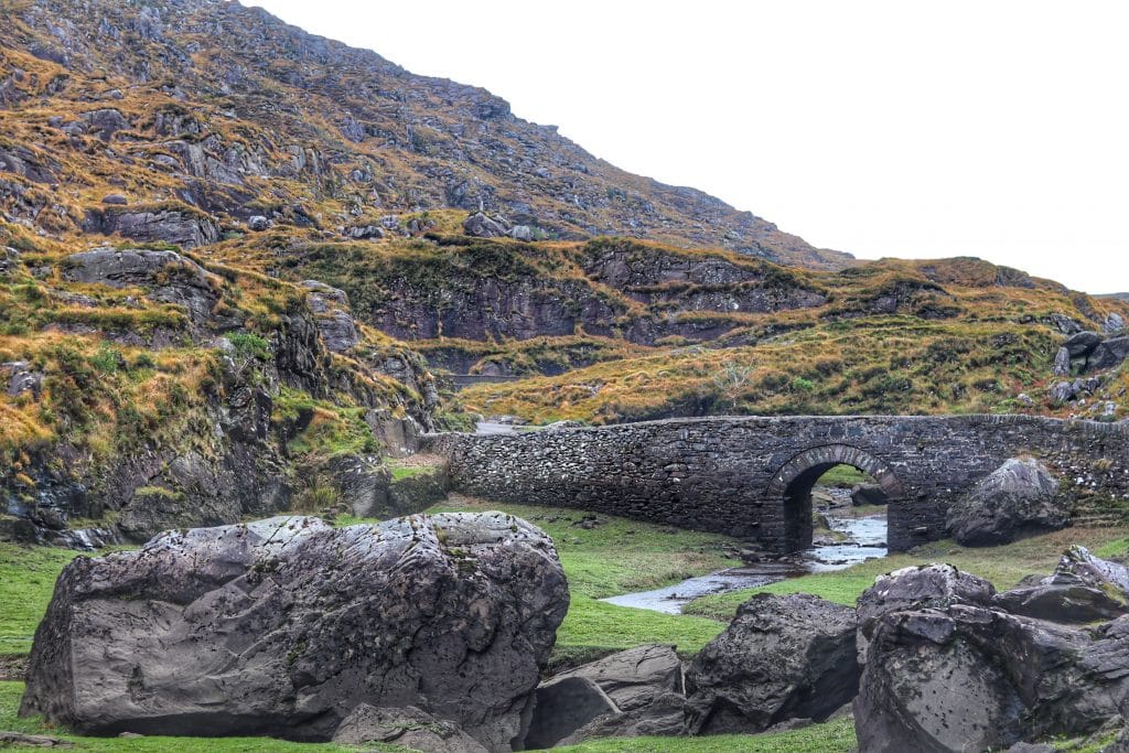 A arch stone bridge near a hill. Photo by Rory Hennessey on Unsplash. #GapofDunloe #Killarney