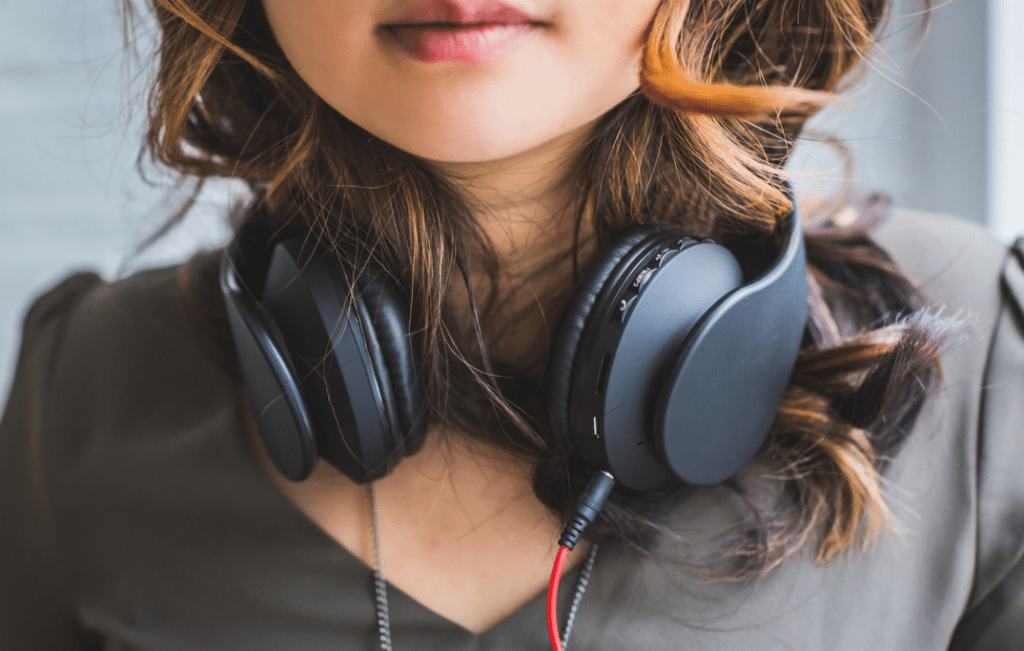 Girl with noise cancelling headphones, which are a travel essential for the digital nomad.