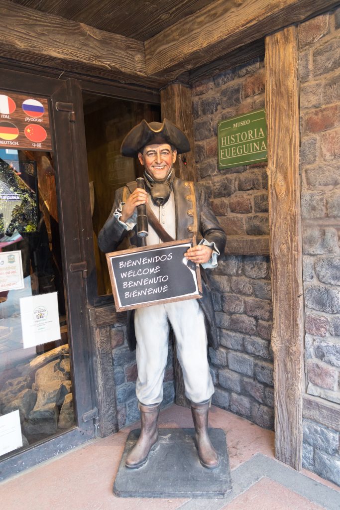 A statue of a sailor holding a welcome sign outside a museum. Just one of the many reasons to visit Ushuaia, Argentina. #ushuaia