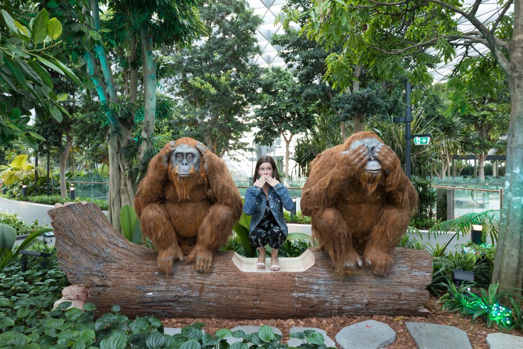 A girl crouching between two orangatans at the Changi airport. #changi #changiairport #changijewel