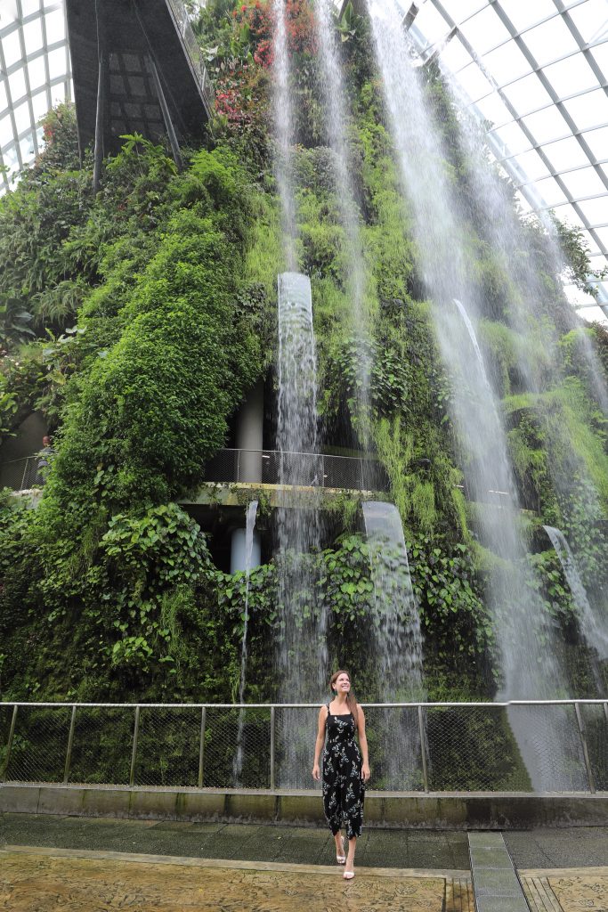 A girl walking in front of waterfalls at the Cloud Forest in Singapore. #cloudforest #singapore