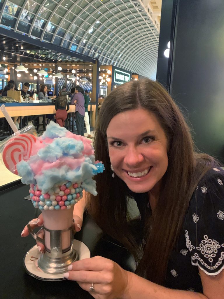 A girl holding a huge cotton candy milkshake. #marinabaysands #singapore