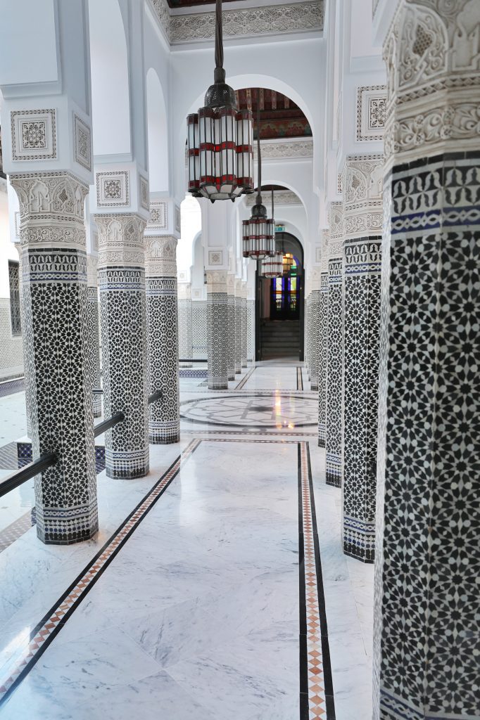 White and black moroccan tile pillars down a hallway at La Mamounia. Discover the many alluring reasons to visit Marrakesh, Morocco. From must-see sights to can't-miss experiences, here's the very best of Marrakesh! #marrakesh #lamamounia
