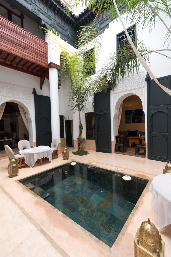 The courtyard of a riad with a pool and palm trees. #marrakesh #riad