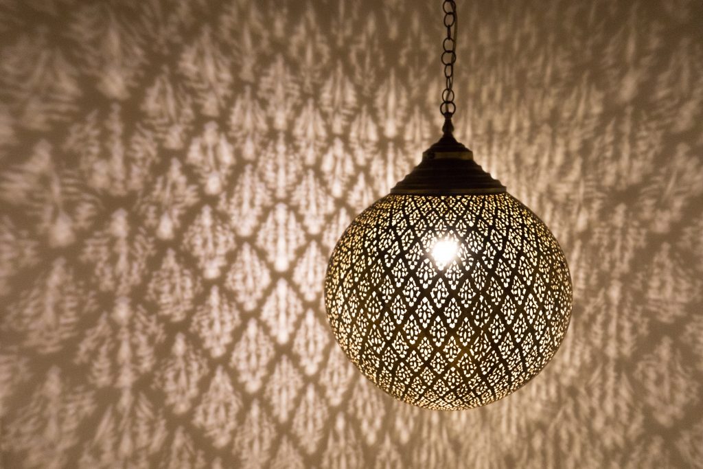 A Moroccan light fixture casting intricate designs on the wall with its shadow. #marrakesh #moroccanlight