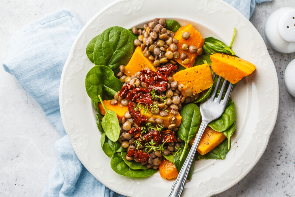 A plate of food with pumpkin, spinach, and seeds. #travelhealth