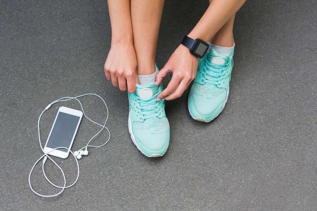 Person tying their shoes. Discover why these 10 expert tips for staying healthy while traveling will make your jetsetting a whole lot more enjoyable! #travelhealth