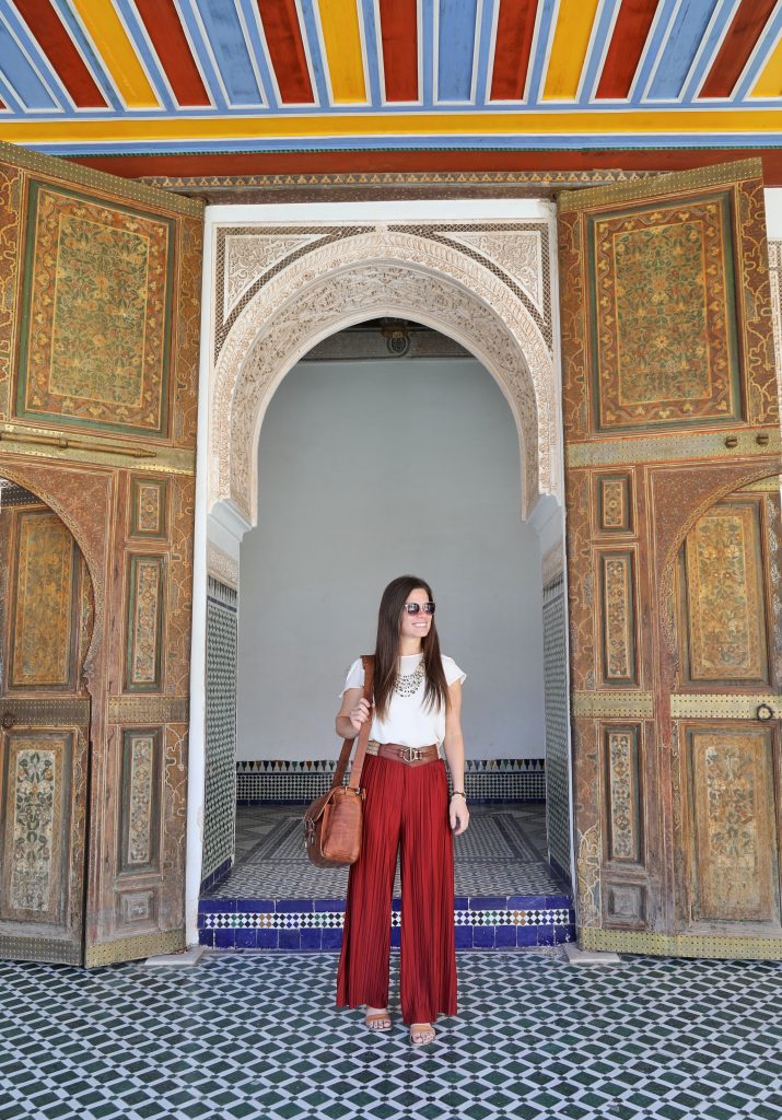 A girl standing in a colorful doorway in Morocco. Visiting all 7 continents is a huge bucket list experience for many!