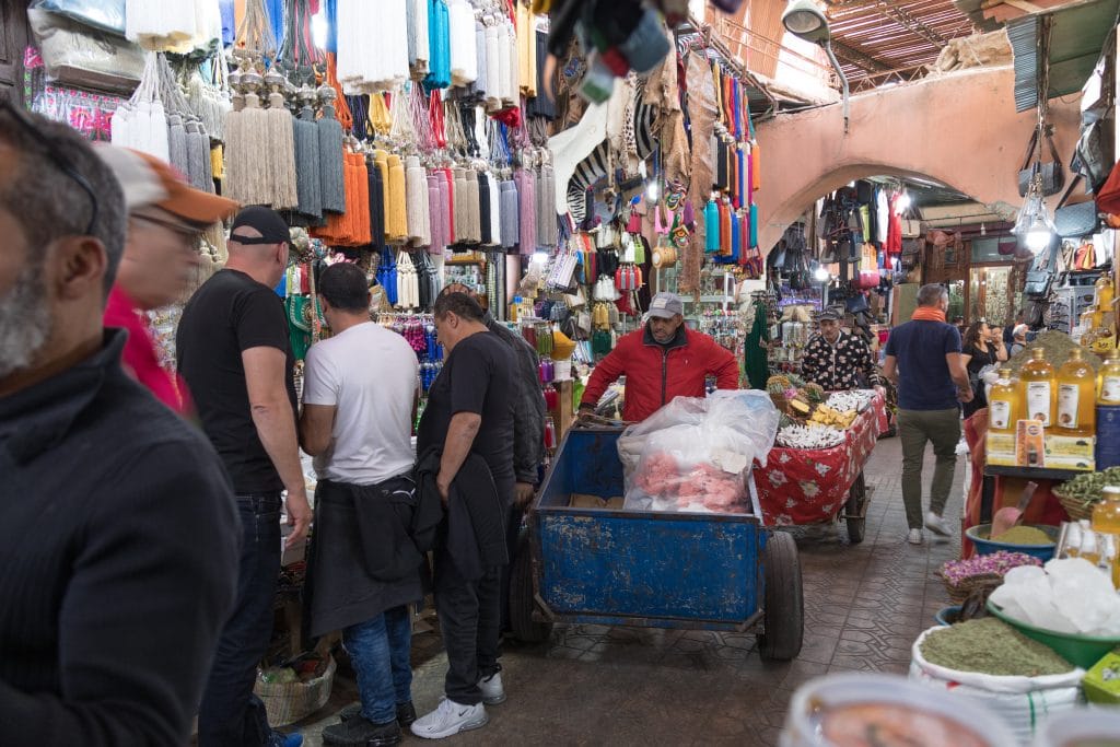 A busy walkway in the medina souks of Marrakesh. Discover the things you need to know before visiting Marrakesh. #thingstoknowbeforevisitingmarrakesh