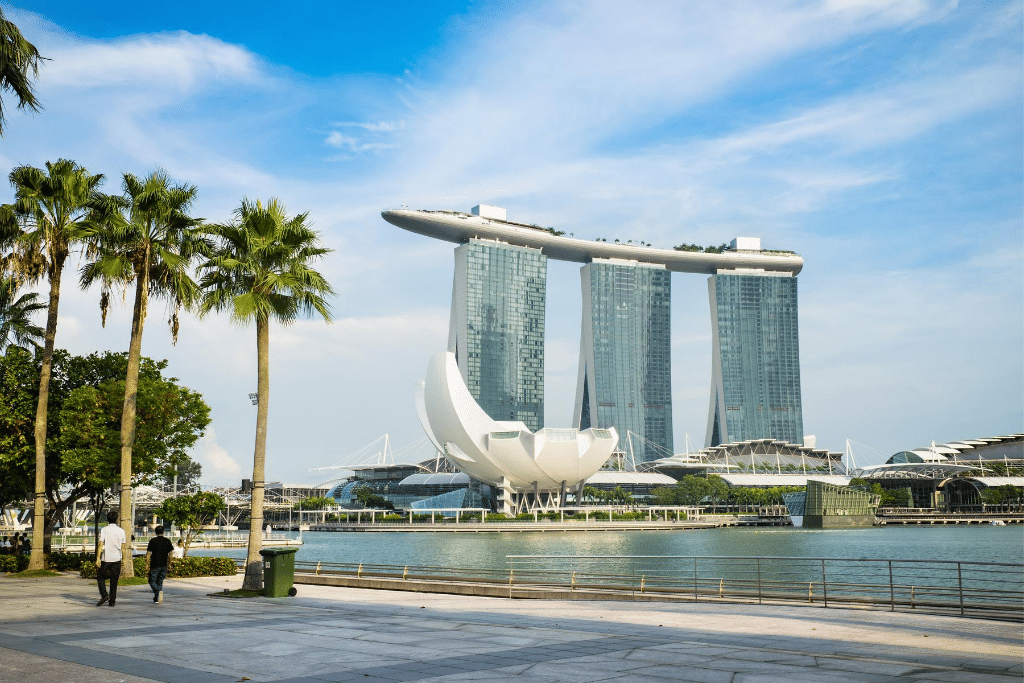 The Marina Bay Sands hotel in Singapore with palm trees along the water. 