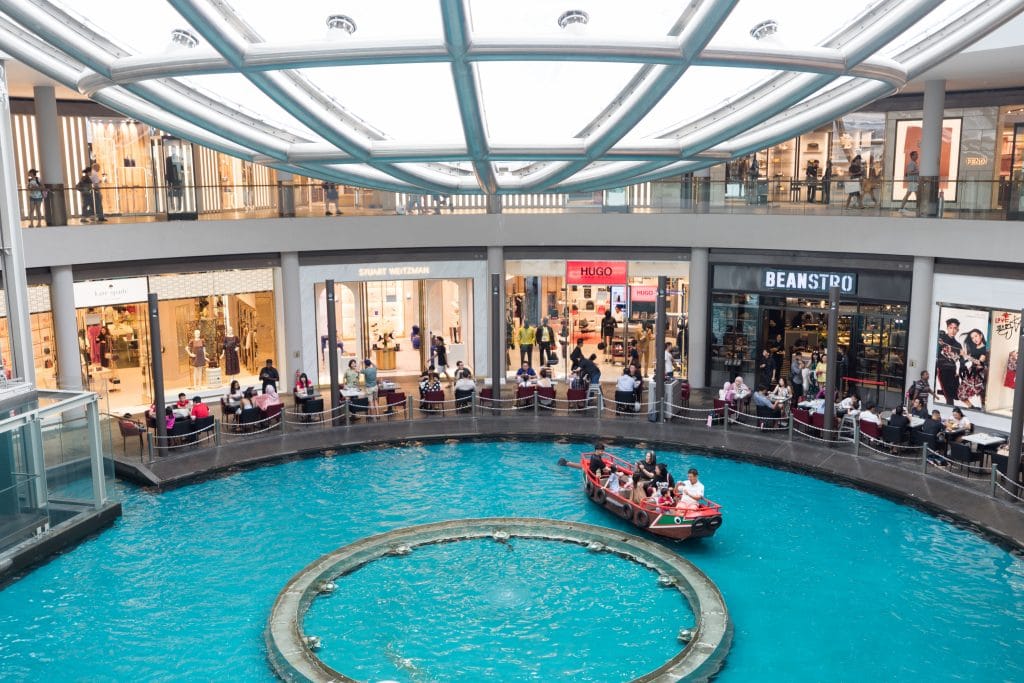 A gondola floating through a waterway at the Marina Bay Sands Singapore. Find out what it's really like to stay at the Marina Bay Sands Singapore. What to expect, what's nearby, and what you shouldn't miss!