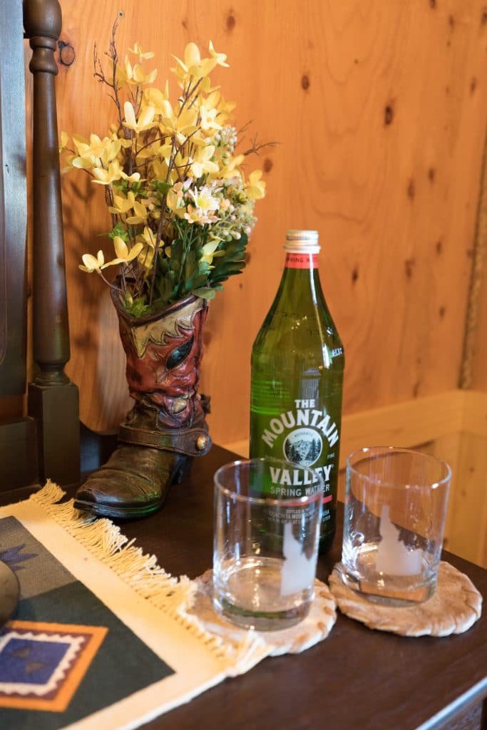A boot with flowers and bottled water with Idaho glasses at Maison Tetonia.