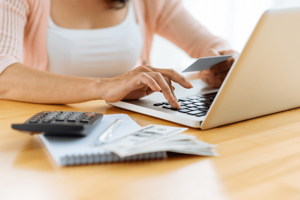 A woman paying bills online. Learn expert tips to help you prepare for vacation so you can truly enjoy your time away. 