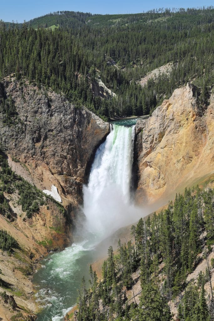 A waterfall in Yellowstone with a snowy heart to the left of it. One of the most unique moments of 2020.