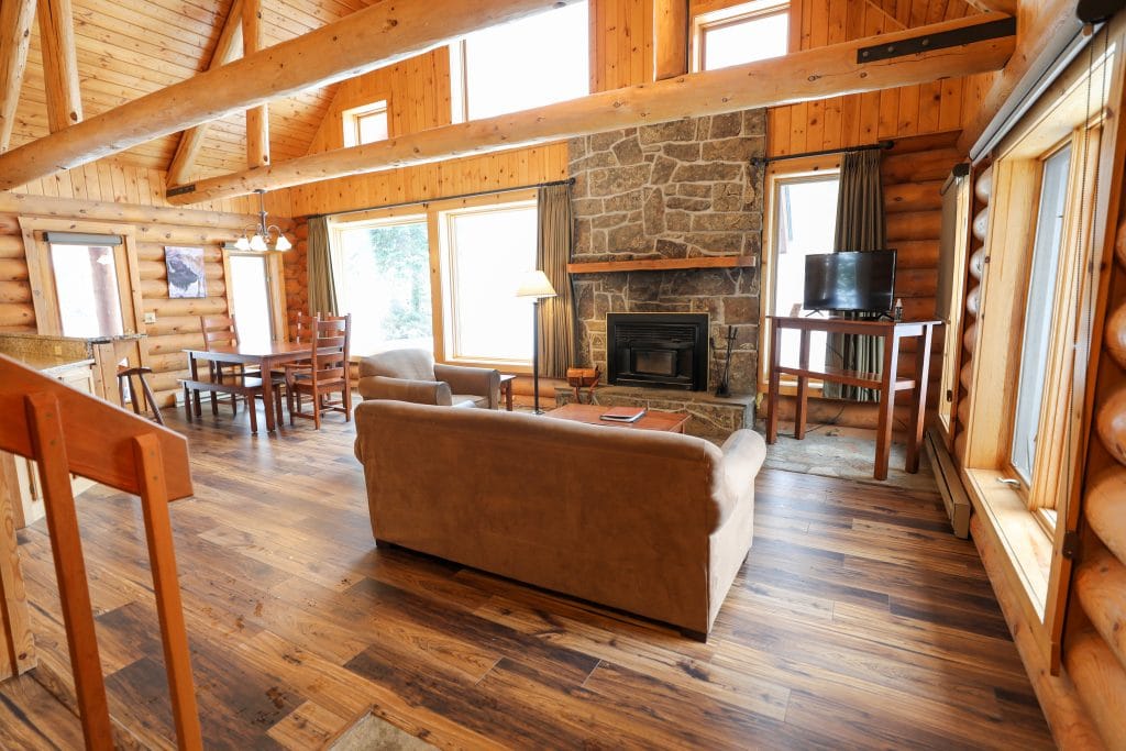 The log cabin interior with a fireplace at the 320 Guest Ranch. #320guestranch