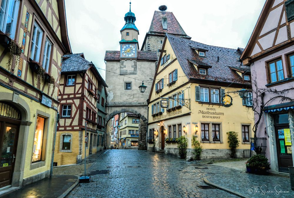A rain-soaked street of half-timbered houses in Germany. Discover why Rothenburg ob der Tauber in Germany is a must for your fairytale bucket list (and what you can't miss while you're there!)
