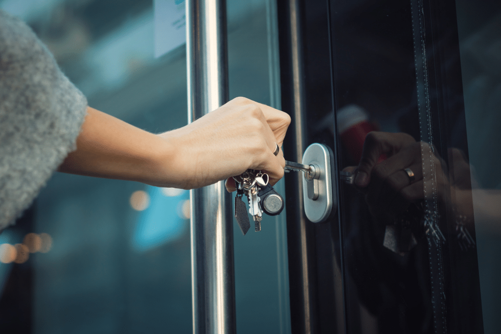 Woman opening front door. Learn 5 ways to keep your home safe while you're away from home and traveling the world. From how to thwart theives to security systems.