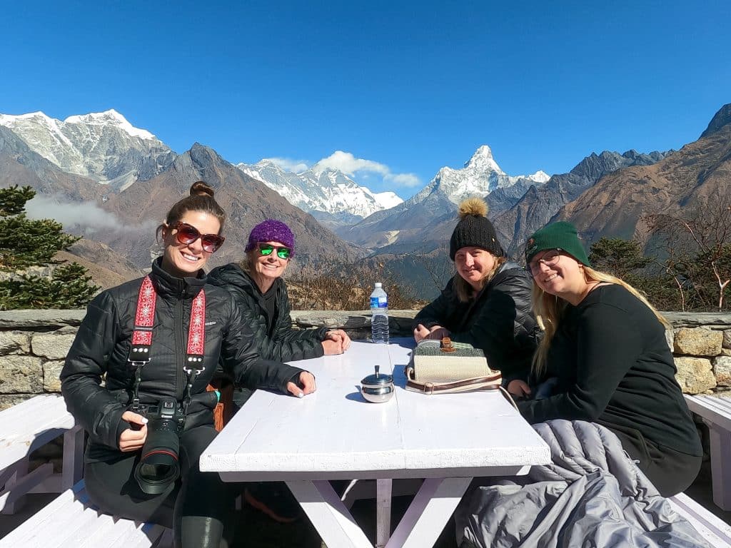 Ladies sitting around a picnic table with Mount Everest Base Camp in the background.
