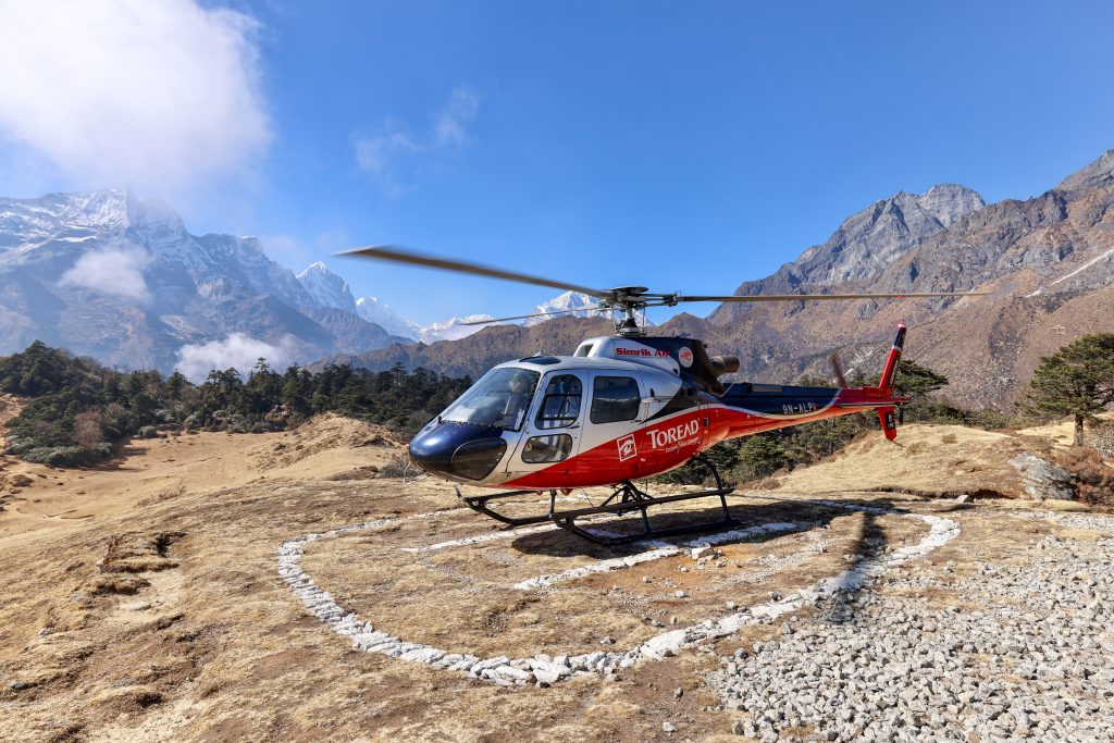 A helicopter on the side of the mountains in Nepal near Mount Everest Base Camp.