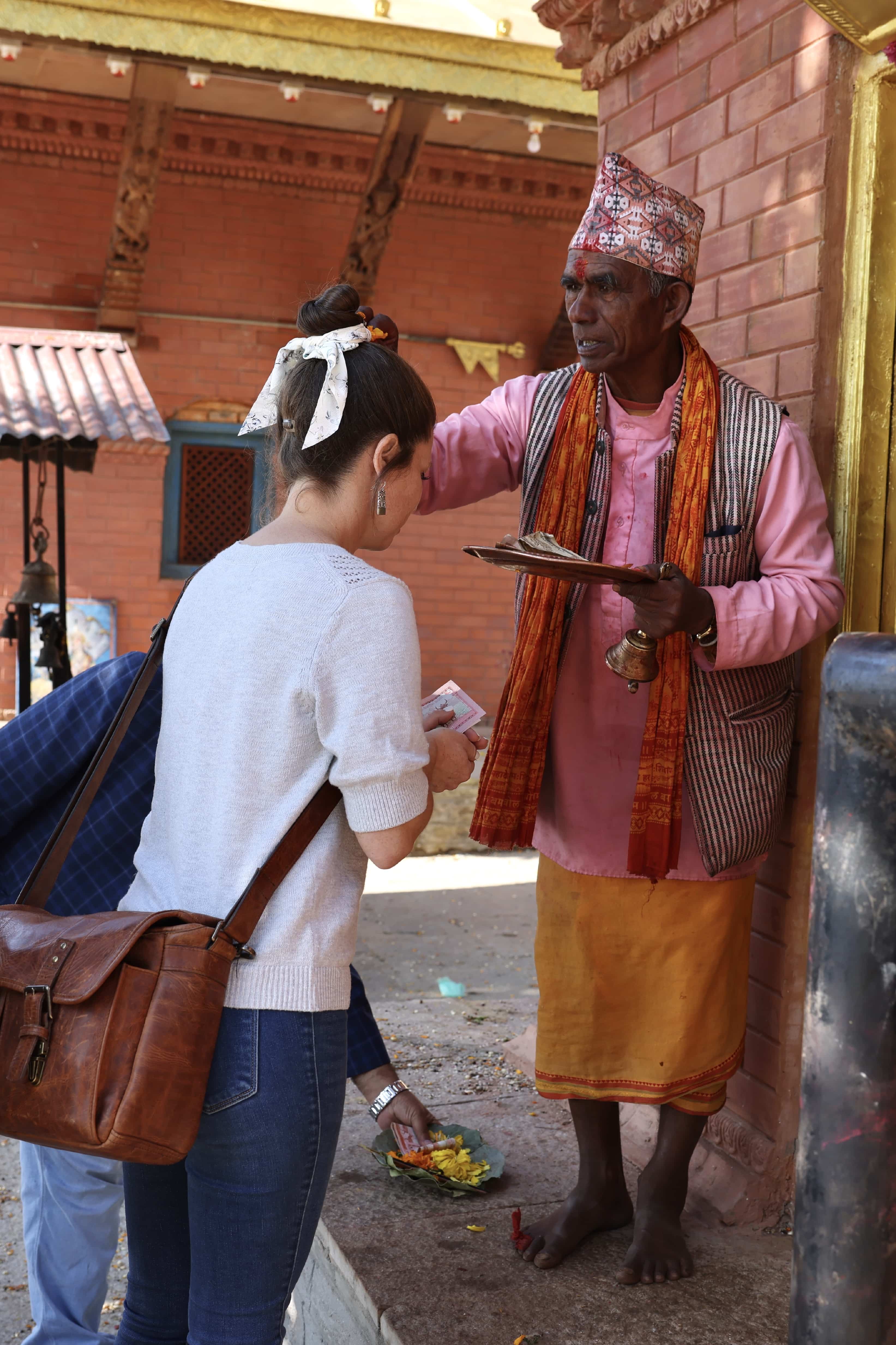 A young woman being blessed by a nepali priest.