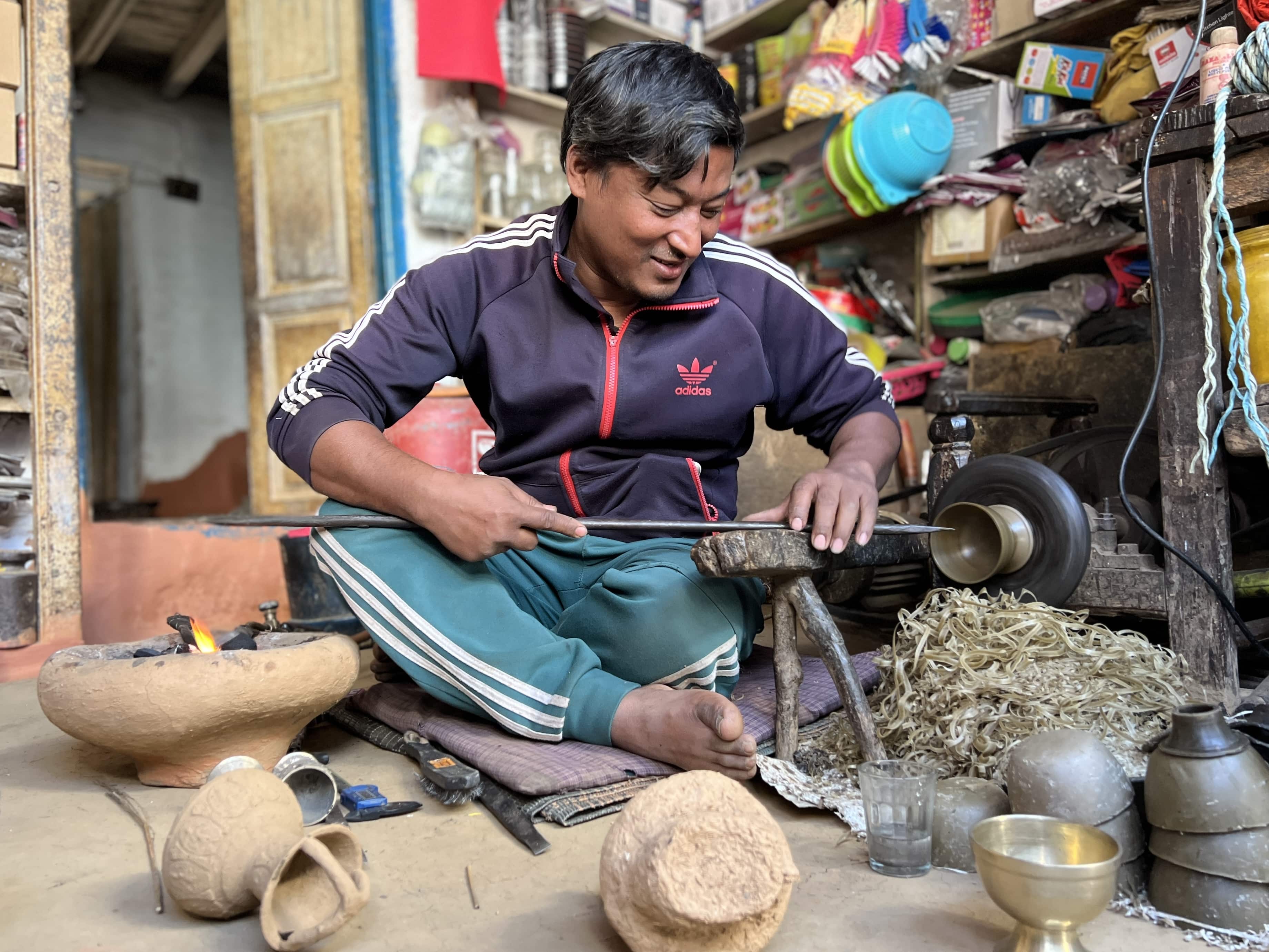 A man creating a silver goblet at a shop in Khandbari, Nepal.