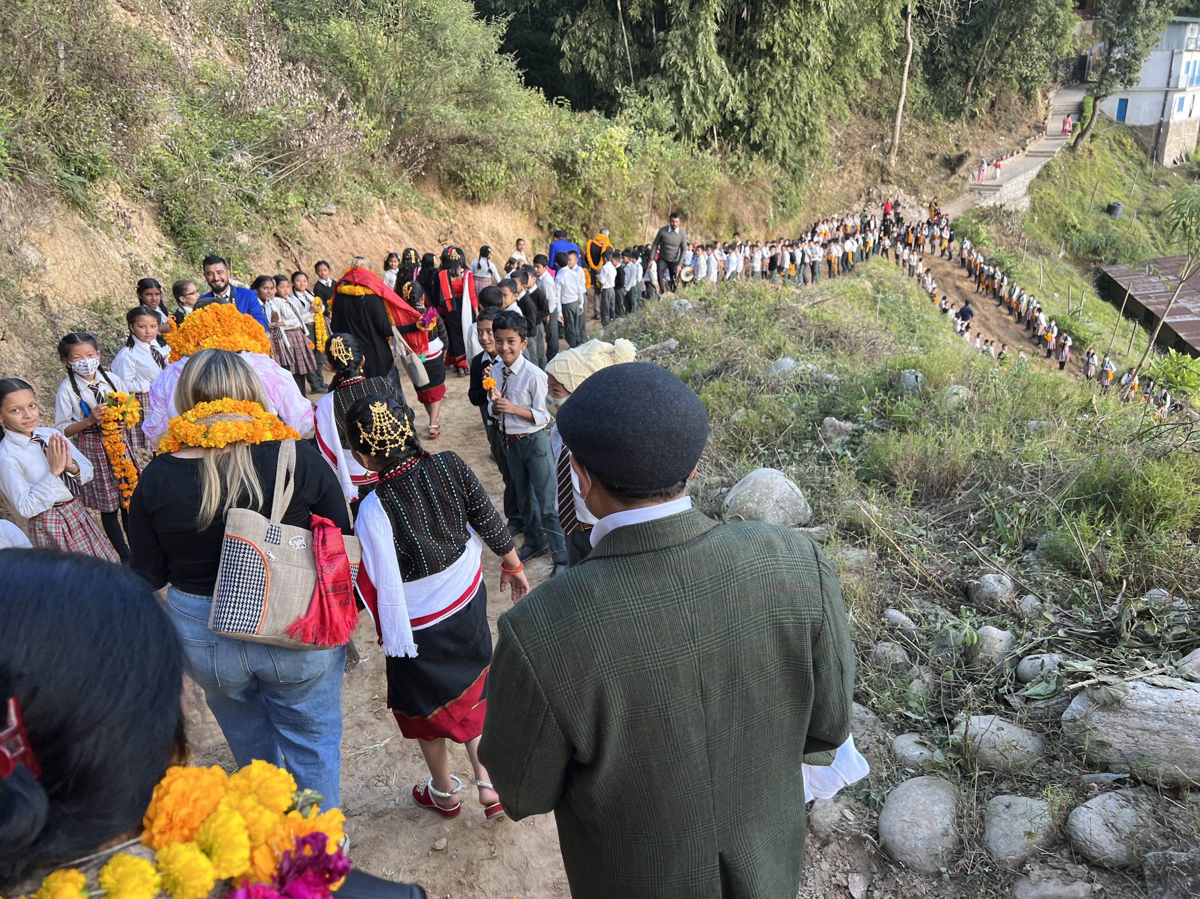 Nepali children lining the road holding lays to welcome guests to their school.