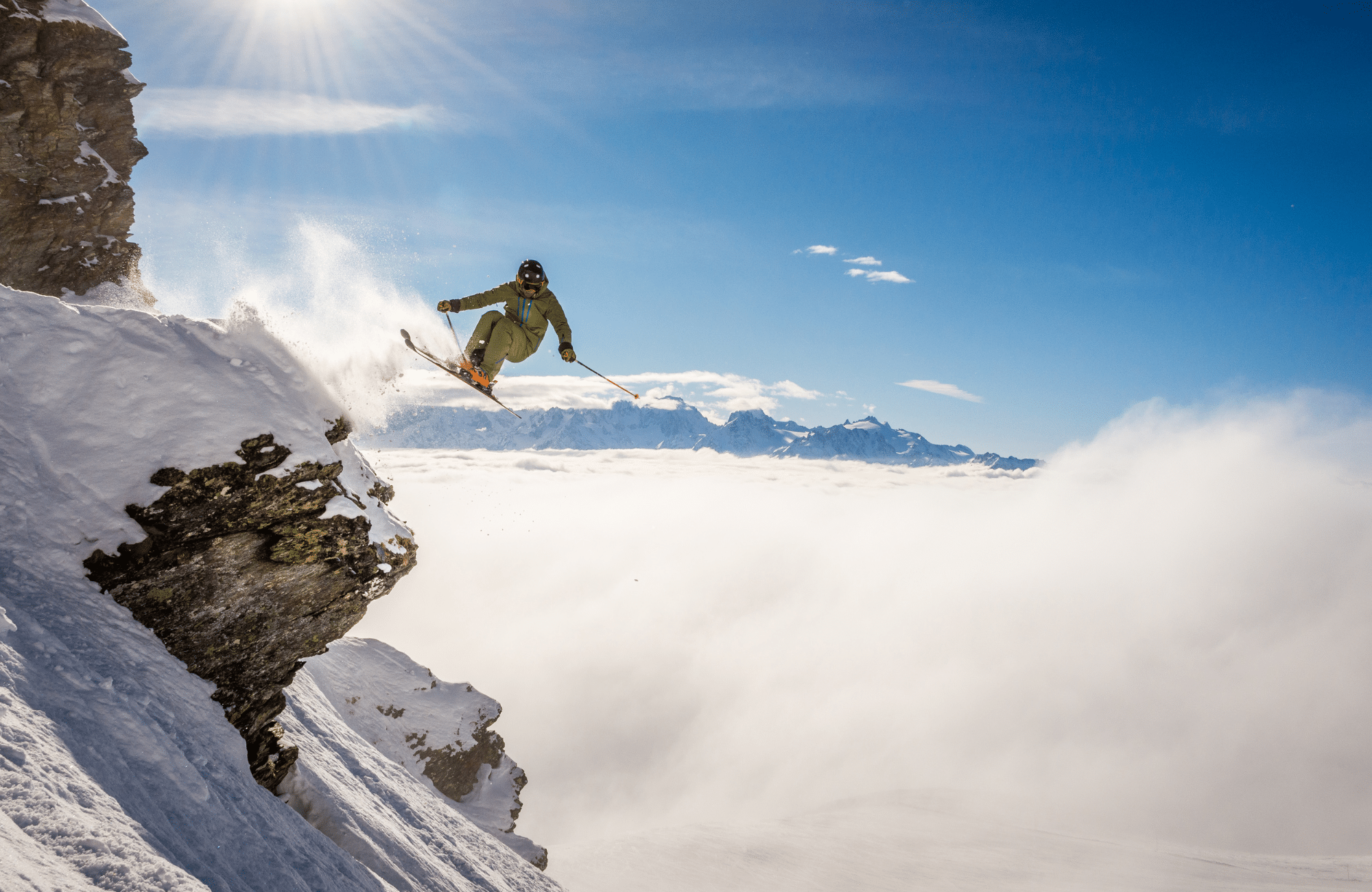 A skiier jumping off a cornice in the Alps.