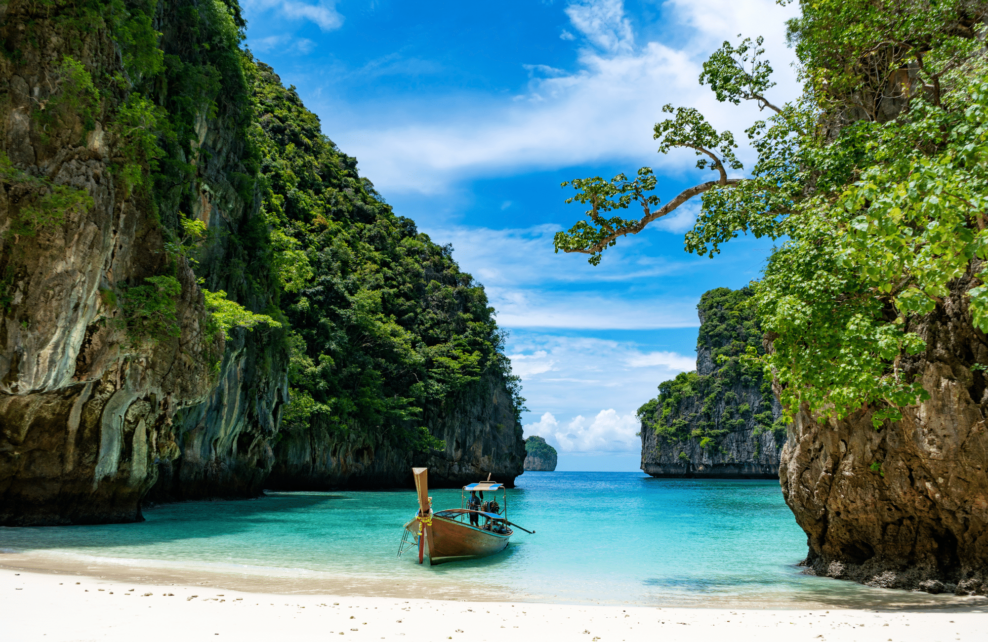 A traditiional Thai boat in the turquoise waters of the Phi Phi Islands.